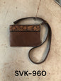 Brown leather handbag with floral embossing on a beige surface, labeled SVK-960.